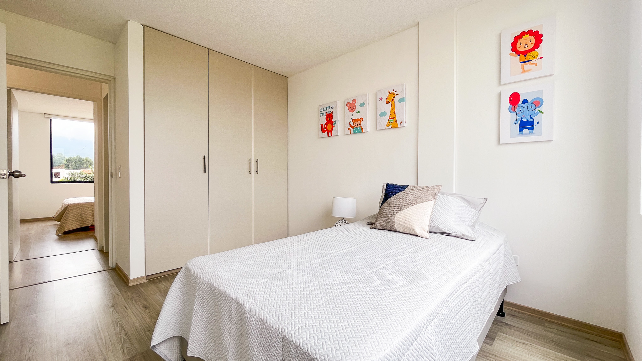 Dormitorio infantil con cama sencilla, closet de pared completa y cuadros de animales, El Dean