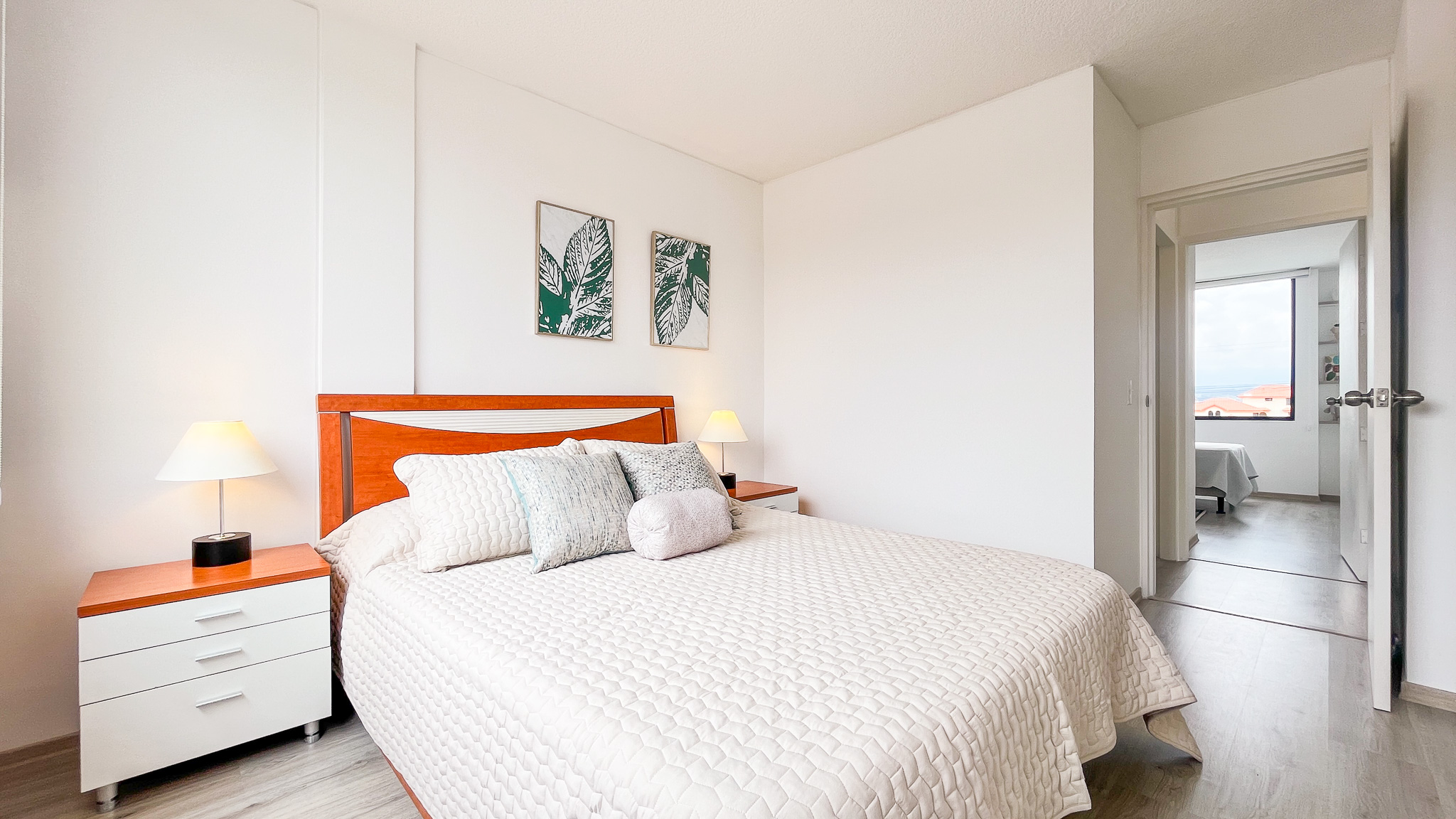 Dormitorio principal con cama de cabecera naranja y ventana al fondo, El Dean