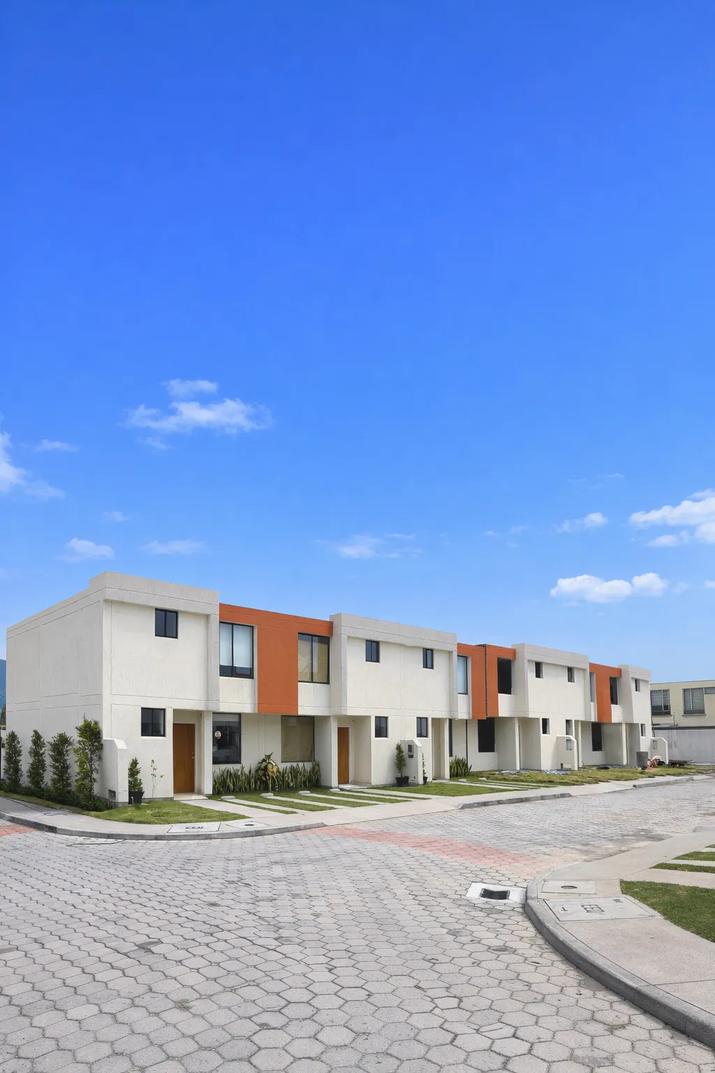 Casas blancas con paneles teja y calle adoquinada bajo cielo azul, foto vertical, Santa Lucía