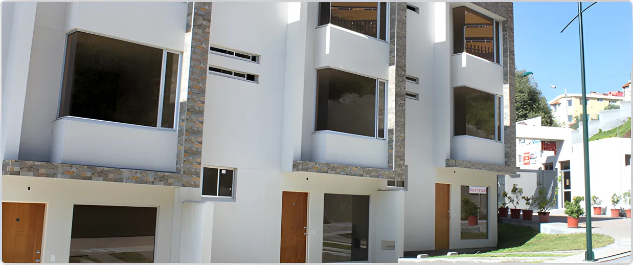 Fachada de casas blancas con balcones y puertas de madera, Paseo del Sol 2