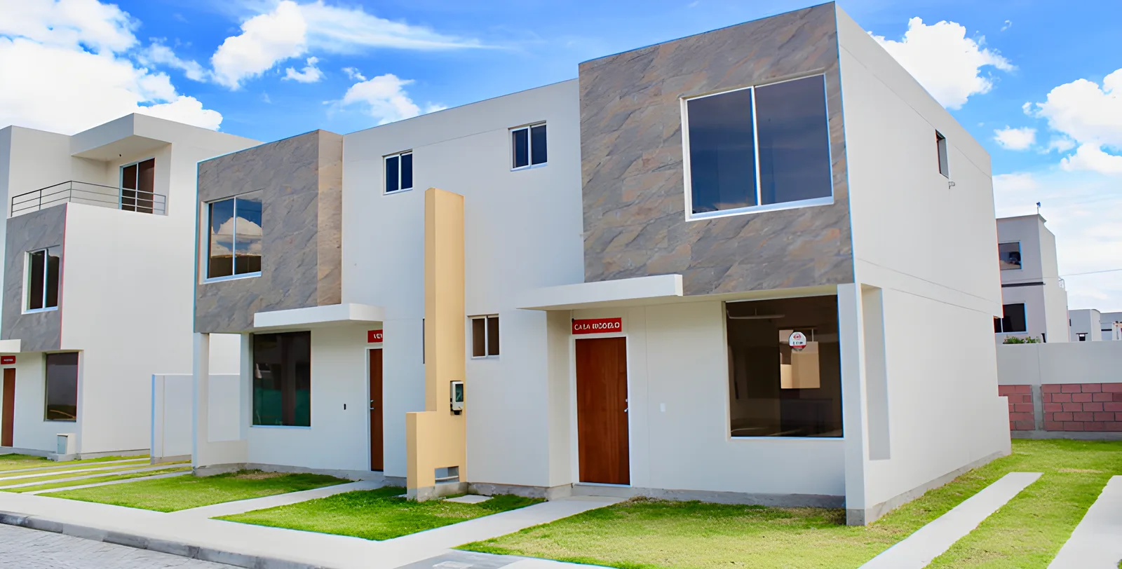 Casas blancas con paneles de piedra café y calle de adoquín, Jardines del Dean 2