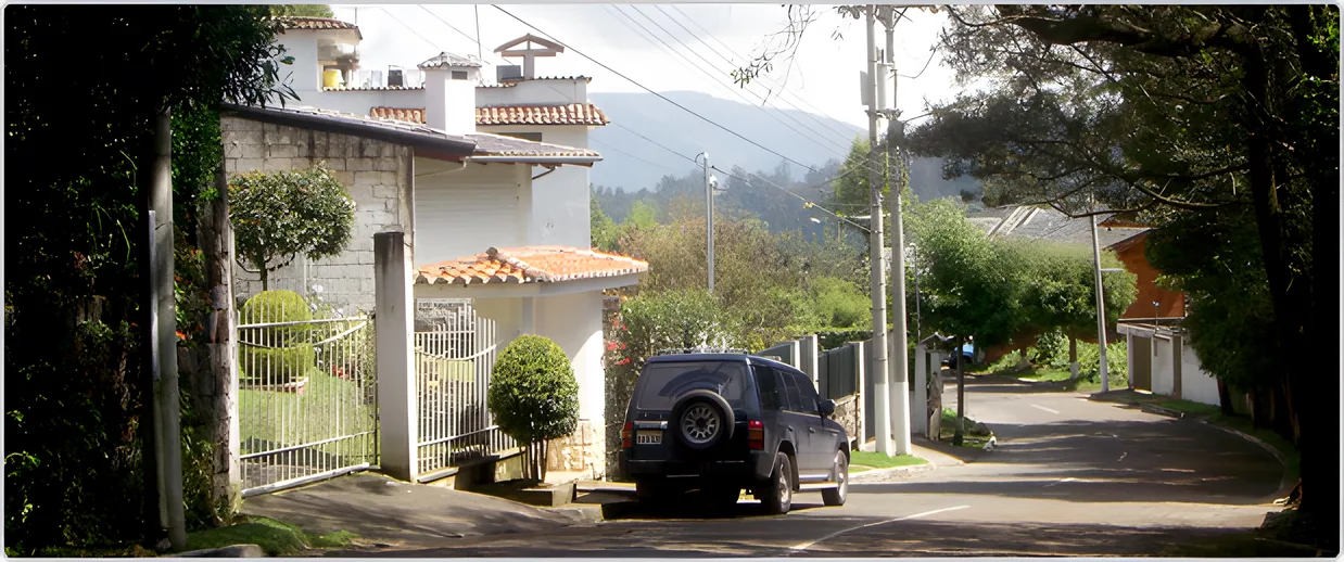 Casa blanca con techo de teja y un jeep en un camino arbolado, Portal de Los Chillos 1