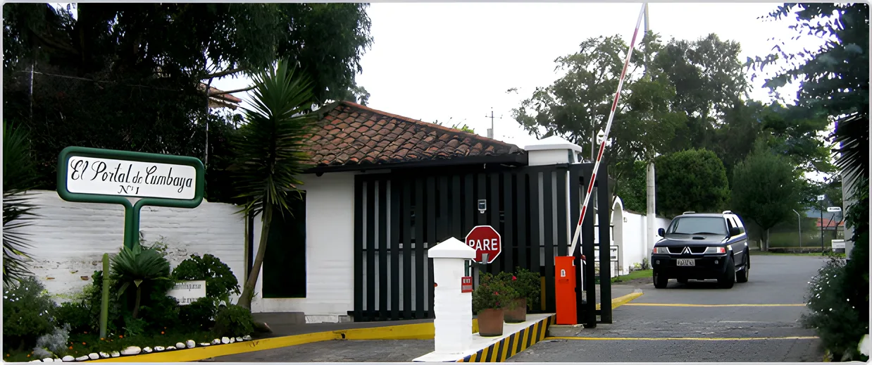 Garita de teja con el rótulo El Portal de Cumbayá y un auto en la entrada, Portal de Cumbayá 1