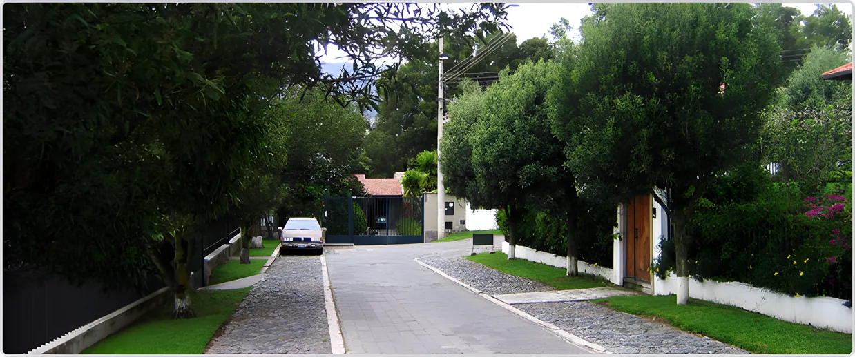 Calle arbolada con un auto blanco al fondo, Portal de Cumbayá 1