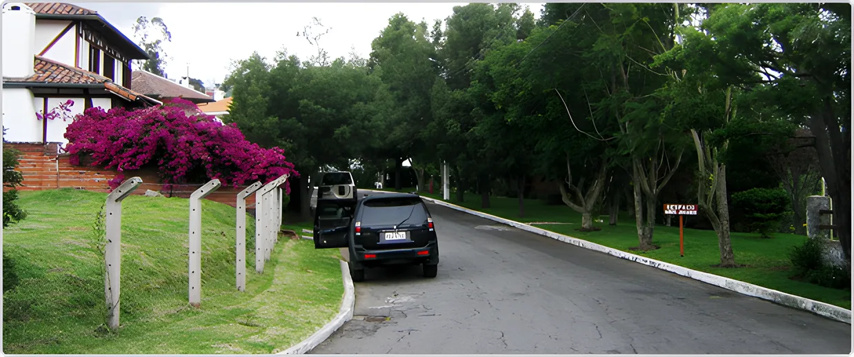 Calle con jardín florecido y una camioneta oscura, Portal de Cumbayá 2
