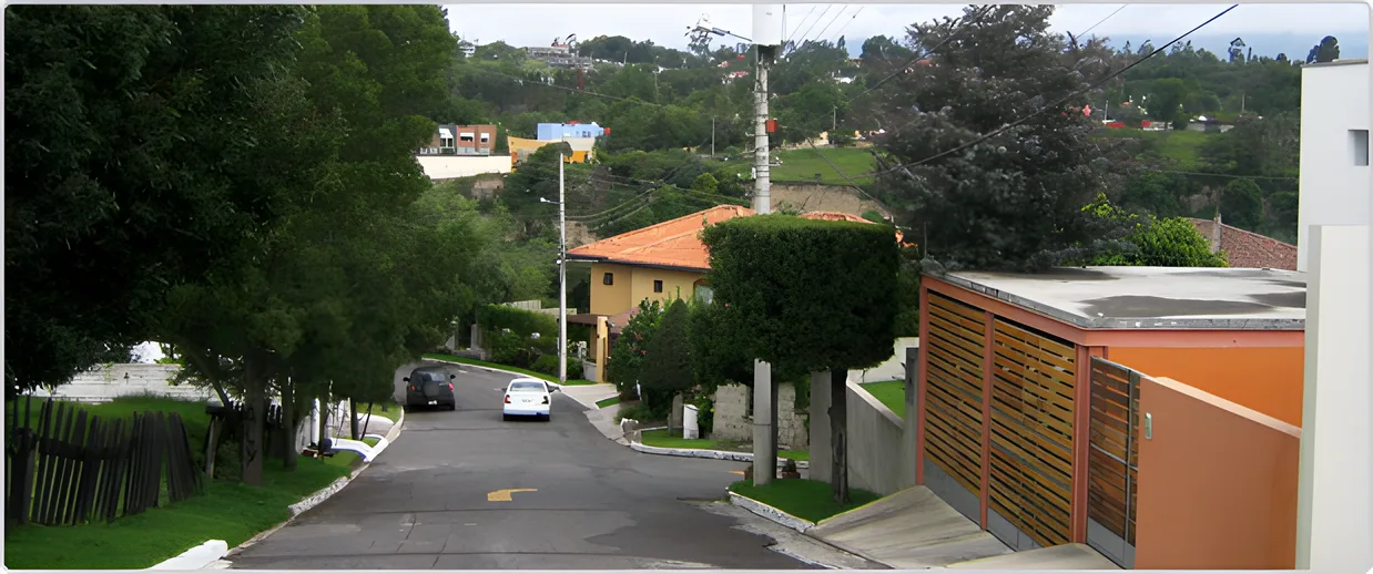 Calle que baja entre casas y árboles, Portal de Cumbayá 2