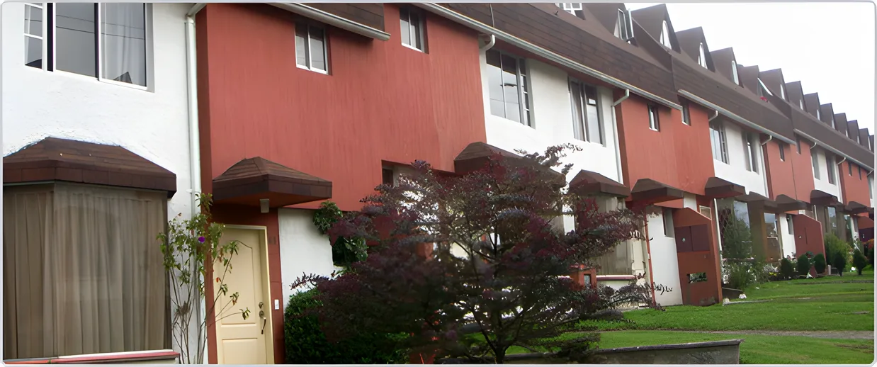 Hilera de casas rojas con techos a dos aguas y jardín, Ciudad Jardín 1