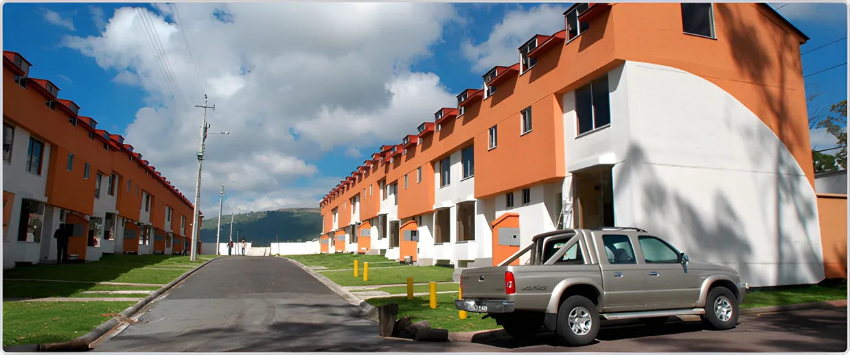 Calle con edificios anaranjados de tres pisos y una camioneta, Ciudad Jardín 2