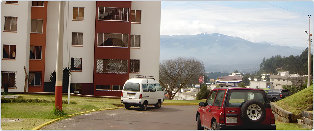 Edificio rojo de varios pisos con las montañas al fondo, Puerta del Sol II